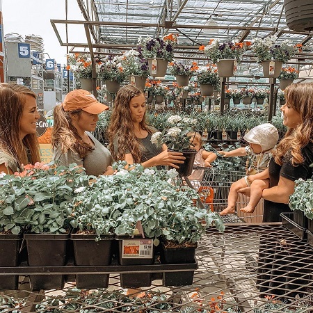 Anna Duggar carrying her youngest daughter in the flower nursery with her three Duggar sister-in-laws.