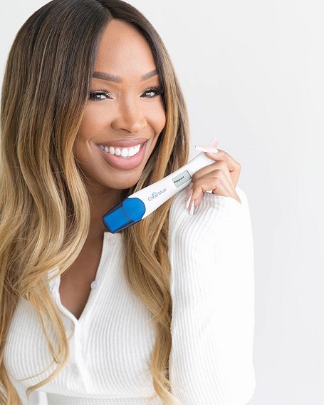 Malika Haqq holding a pregnancy test device, a post on social media.