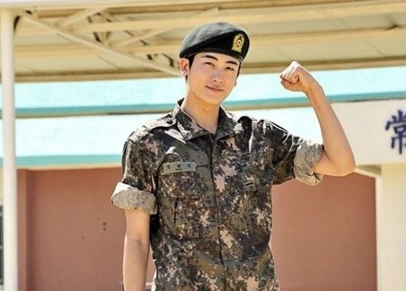 Hyung-Sik in a Korean Military uniform while shooting for the movie, 'Real Man', holding his arms up as if to bulge his biceps.