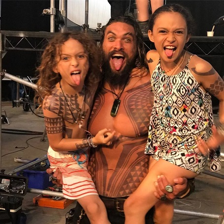 Jason Momoa carrying Nakoa-Wolf in his right hand and daughter Lola in his left hand as they all take the fierce pose by taking their tongues out.