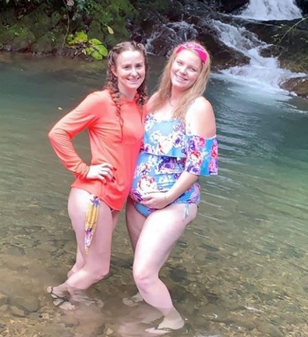 Leah and her sister Victoria in knee-deep water.