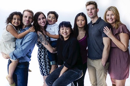 Zack (holding) Jett and Deborah holding Ezekiel while they pose with their six youngest kids.