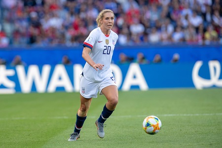 Allie near the ball at the Olympic games against France. Alone in her US Women's soccer uniform.