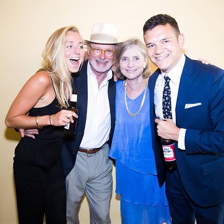 (from left) Molly, her father, mother and Ben posing close to each other for a photo. Two people in the side holding beers.