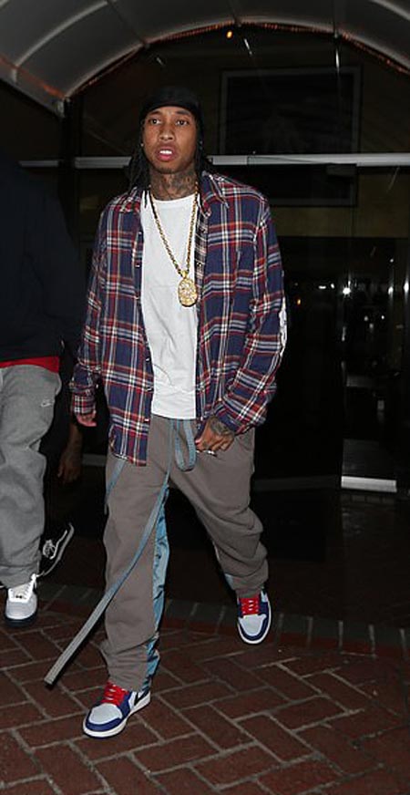 Tyga getting in a hotel being photographed by paparazzi.