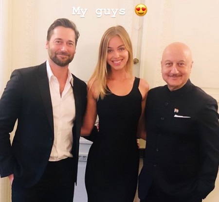(From left) Ryan, Liz and Anupam kher standing arm in arm. 'My guys' written over the couple's head.