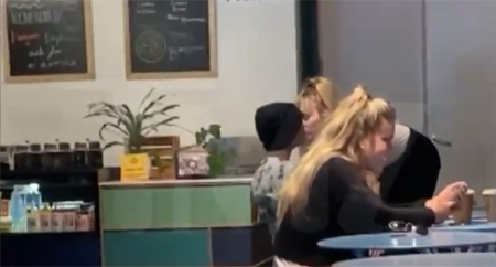 Cody and Miley sharing a kiss while waiting for their food.