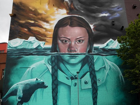 The mural of Greta Thunberg as described above, face partly under glacier water.