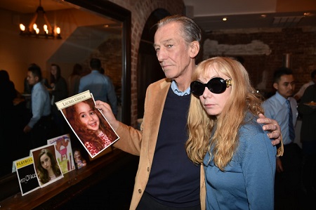 Parents Andrew and Elizabeth Griggs holding a photo of Laurel at a gathering on Sunday.