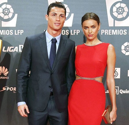 Cristiano in a black suit and Irina in a red dress.