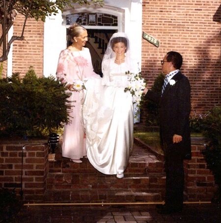 Valerie during their wedding as she's walking down the stairs with her mother as William extends out his hand towards her.