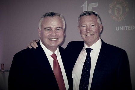 Alex Ferguson with his right hand in Eamonn's right shoulder as they both look at the camera smiling.