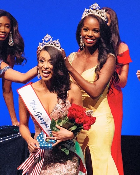 Alyssa Beasley crowning Liane Mrs. Georgia America 2018 as they are smiling.