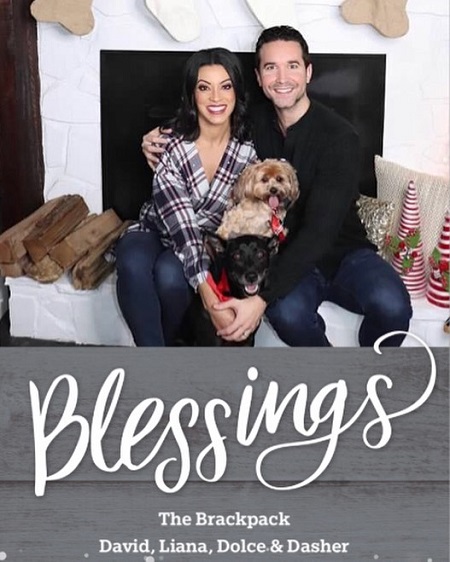 A family pic of Liana, David and the two dogs in the middle. 'Blessings' written below the photo.