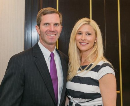 Britainy (right) with her husband Andy Beshear (left) smiling for the camera.