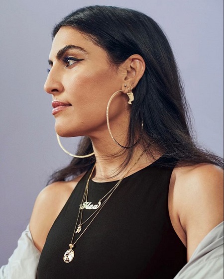 Melody Ehsani looking sideways with huge ringed-earrings.