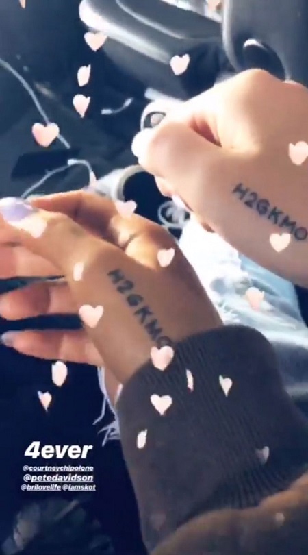 Ariana and Courtney's hands with that 'H2GKMO' tattooed.