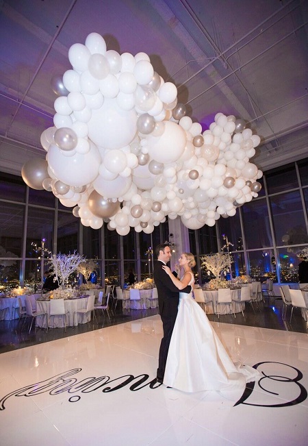 The wedding view of Iliza Shlesinger and Noah Galuten with white balloons in the air.
