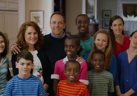 Matt and Glenna with their nine kids, the four adopted kids in the middle with the parents and two go the daughter's are only half in the frame of the photo.