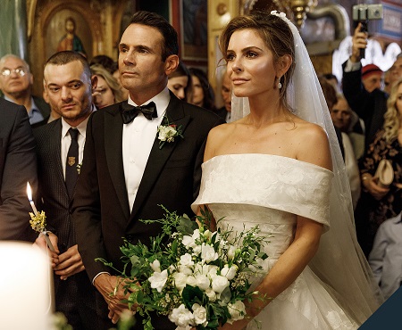 A scene from Keven Undergaro and wife, Maria Menounos's second wedding in Greece. The two standing side by side with a bouquet in her hand.