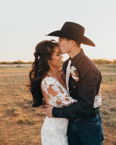 Jess Kissing the forehead of Hailey Kinsel in wedding dresses.