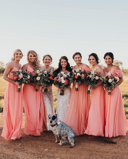 Hailey Kinsel (center) with the maid of honor (to her right) and the five bridesmaids, two beside the maid of honor and three beside the bride. A dog pops in front of the bride.