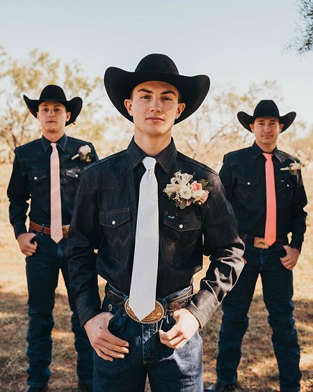 An iconic cowboys pose with Jess Lockwood and two of his groomsmen - both hands in one slot of the belt.