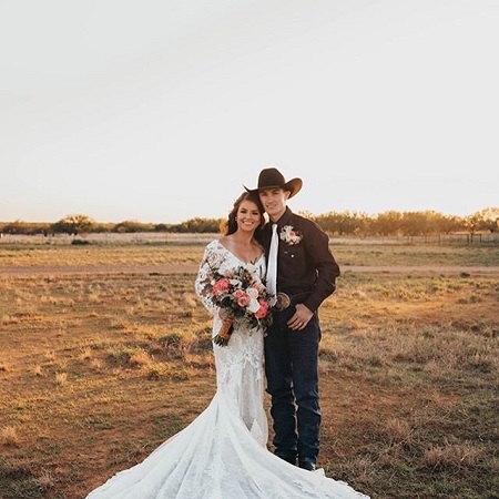 Lockwood and Kinsel facing the camera to take a full picture with the bride holding the bouquet.