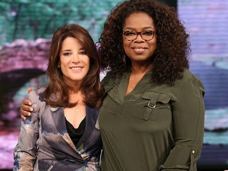 Oprah Winfrey holding Williamson by the shoulder.