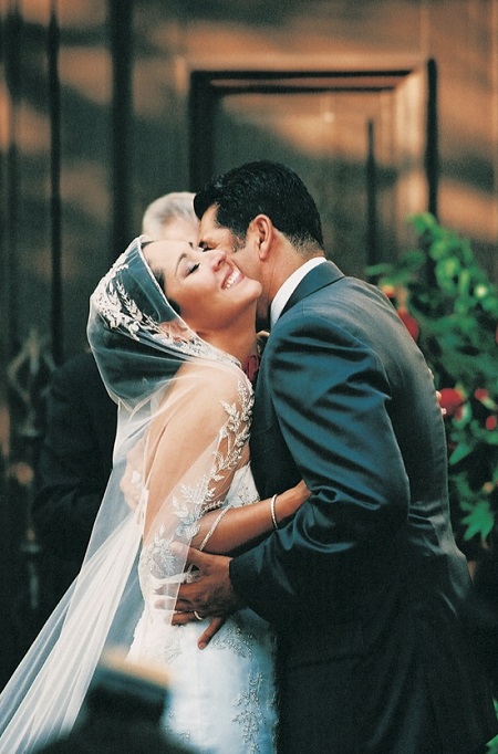 Lynette Romero with husband David Angulo on their wedding day, cozying and laughing it up in their wedding dresses.