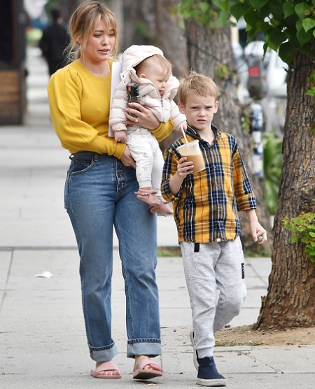 Hilary Duff in an outing with son, Luca Cruz, and daughter Banks Violet in her arms.