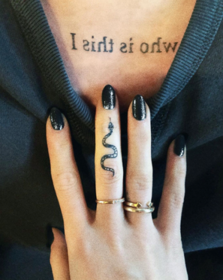 Reclaiming the snake by getting a snake tattoo on her middle finger.