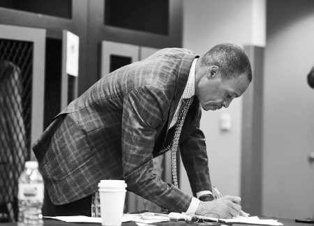 Gus writing on his desk.