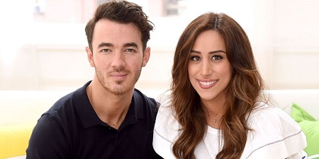 Kevin Jonas with his Wife Danielle Jonas Deleasa, smiling at the camera.