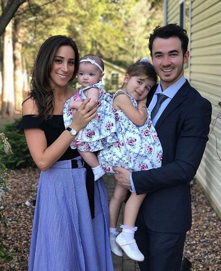 Kevin Jonas with his wife Danielle Jonas holding their daughters, Alena and Valentina, in their respective arms.