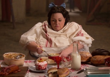 Chrissy Metz in a scene where she is eating at a dinner table, from 'American Horror Story'.
