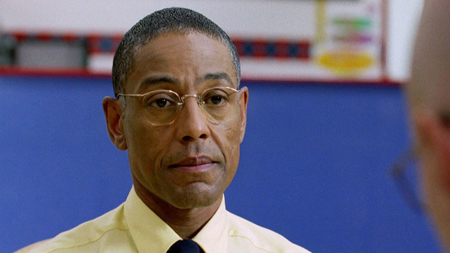 Giancarlo Esposito, with his trademark no expression look, looks at Walter White with dead eyes.
