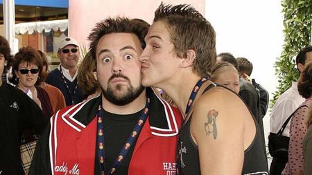 Jason Mewes kisses Kevin Smith on the cheek.