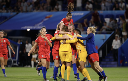 USWNT celebrate in a pile after their win against England