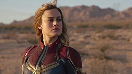 Captain Marvel on earth, looks off screen.