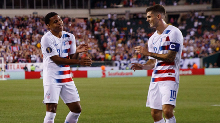 Christian Pulisic celebrates a goal with his team mate.