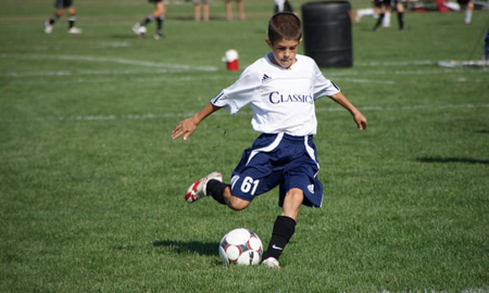 Christian Pulisic as a small boy kicks a ball during training camp.