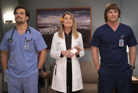 Elle Pompeo as Dr. Meredith stands in between two men.