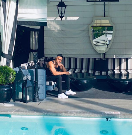 Jay sean sitting infront of his swimming pool