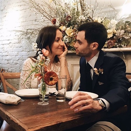 Domino Kirke looking soulfully at her husband Penn Badgley at their first wedding reception.