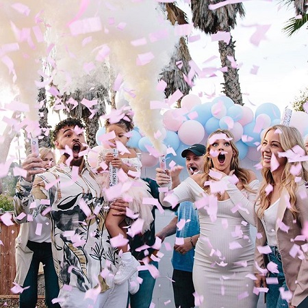 Taylor Selfridge gasing with surprise as pin confetti flies out of their launch poles with Cory Wharton also looking shocked while holding Ryder.