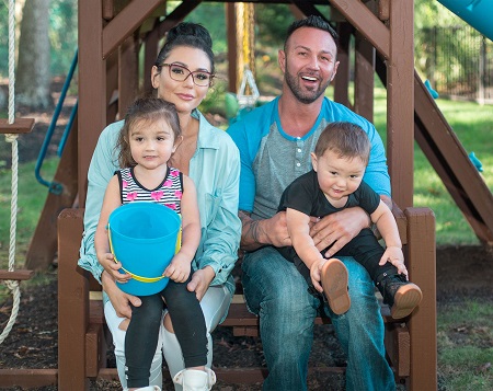 JWoww and Roger Mathews with their two kids in a playground ferris wheel.