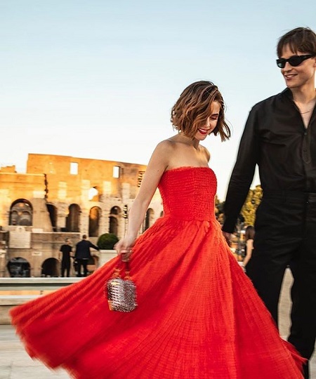 Kiernan Shipka in red smiling with Christian Coppola.