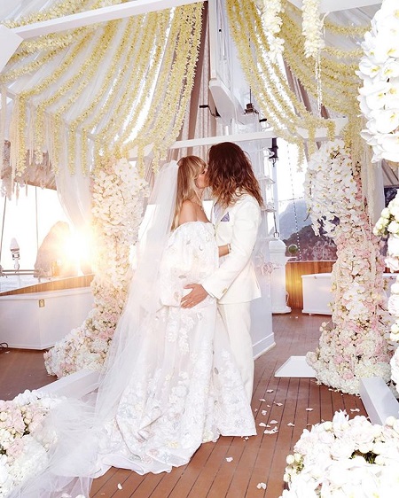 Heidi Klum and Husband Tom Kaulitz kissing in their wedding attires with no one else around.