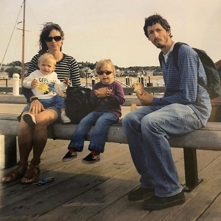 Dolly Wells, husband Mischa Richter with their two kids on a bench eating food.